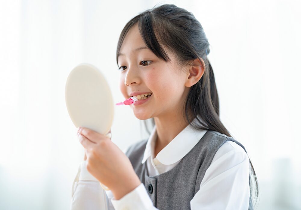 鏡を見ながら歯みがきする女の子